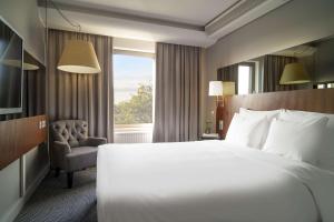 um quarto de hotel com uma cama e uma cadeira e uma janela em Radisson Blu Arlandia Hotel, Stockholm-Arlanda em Arlanda