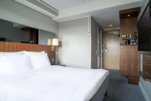 a bedroom with a large white bed and a television at Radisson Blu Arlandia Hotel, Stockholm-Arlanda in Arlanda