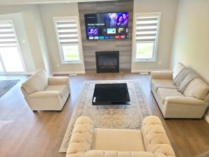 een woonkamer met 2 banken en een flatscreen-tv bij Ottawa-Rockland Newly-built 4 beds house in Rockland