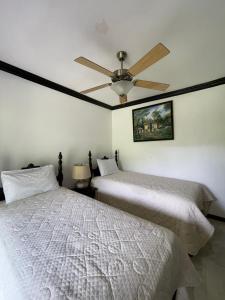 2 Betten in einem Schlafzimmer mit Deckenventilator in der Unterkunft Starlight Chalet & Health Spa in Spa Spring