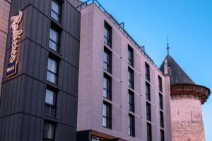 un edificio alto accanto a un palazzo con torre di Radisson Blu Hotel, Rouen Centre a Rouen