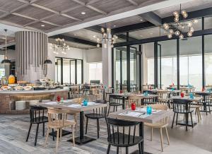 um restaurante com mesas, cadeiras e janelas em Park Inn By Radisson Bacolod em Bacolod