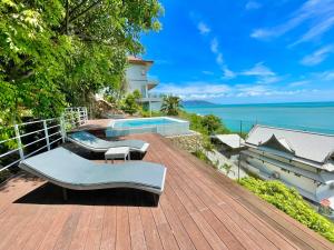 a wooden deck with chairs and a swimming pool at Baan Talay Sai Villa - Panoramic Views 300m to Beach in Koh Samui