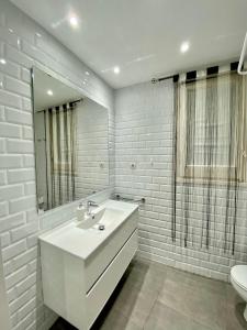 a white bathroom with a sink and a mirror at Central Apartment BCN in Barcelona