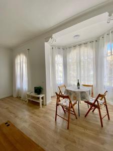 a living room with a table and chairs and windows at Central Apartment BCN in Barcelona
