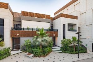 a building with palm trees in front of it at Radisson Blu Hotel Riyadh Qurtuba in Riyadh