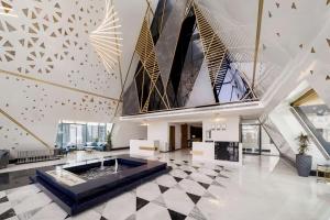 a lobby with a large fireplace and a large ceiling at Radisson Blu Hotel Riyadh Qurtuba in Riyadh