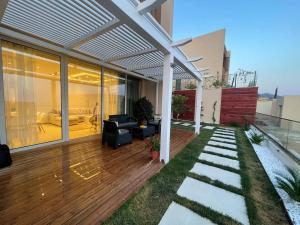 a house with a wooden deck with a pergola at Villa Azure in Palasë