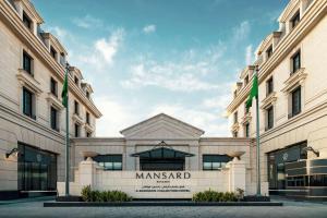 a large building with a sign in front of it at Mansard Riyadh, a Radisson Collection Hotel in Riyadh