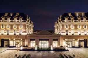 a large white building with two large buildings at Mansard Riyadh, a Radisson Collection Hotel in Riyadh