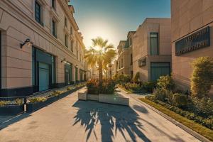 a sidewalk in front of a building with a palm tree at Mansard Riyadh, a Radisson Collection Hotel in Riyadh +193 photos