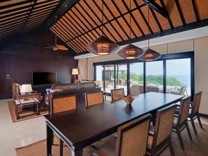 Raffles Bali في جيمباران: غرفة طعام مع طاولة وغرفة معيشة
