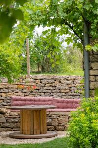 a wooden bench sitting in front of a stone wall at A PAS DE LOUP, Maison de charme sur domaine viticole in Chaux +38 photos
