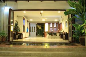 un vestíbulo de un edificio con sillas y plantas en The My Home Resort, en Prachuap Khiri Khan