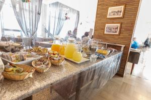 ein Buffet mit Speisen und Orangensaft auf dem Tisch in der Unterkunft Hotel Lily in Rimini