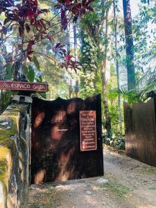 a sign in front of a cave in a forest at Quarto em Residência Familiar - Itatiaia in Itatiaia