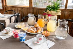 a table with a plate of pastries and orange juice at Hotel Lily in Rimini