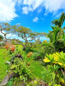 a garden with flowers and a tree on a hill at Gingerhill Farm Retreat in Kealakekua