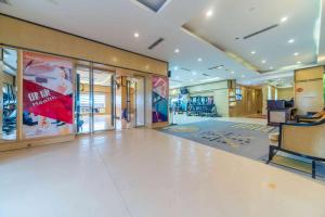 un gran vestíbulo con una zona de espera con una gran ventana en Ramada Yichang Hotel en Yichang