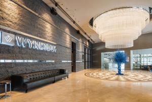 a lobby with a couch and a large chandelier at Wyndham Ankara in Ankara