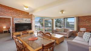 a living room with a table and a tv at Unit 6 52 Fishpen Road, Merimbula in Merimbula