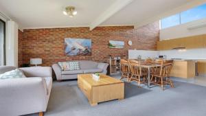 a living room with a couch and a table with chairs at Unit 6 52 Fishpen Road, Merimbula in Merimbula