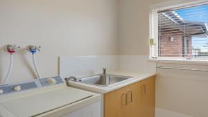a small kitchen with a sink and a window at Unit 6 52 Fishpen Road, Merimbula in Merimbula +10 photos
