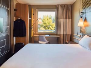 a hotel room with a bed and a window at ibis La Ciotat in La Ciotat