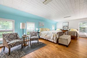 1 dormitorio con paredes azules, 1 cama y sillas en The Cottonwood Inn B&B, en Empire