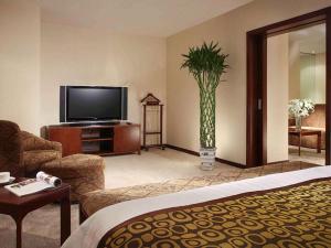 a hotel room with a television and a living room at Mercure Wanshang Beijing in Beijing