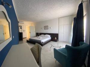 a bedroom with a bed and a table and chairs at Gozo Holiday Apartmen - 2 Bedroom Villa with Shared Pool in Xagħra