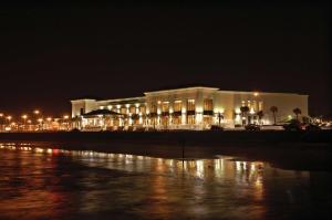 a large building with lights on the water at night at Hilton Galveston Island Resort in Galveston