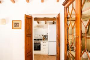 una cucina con frigorifero bianco e piano cottura di CASENUOVE II - Casale con parco e piscina a Castiglioncello