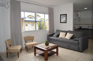 ein Wohnzimmer mit einem Sofa und einem Tisch in der Unterkunft Aires de Cataratas in Puerto Iguazú