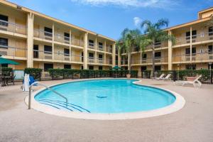 a large swimming pool in front of a building at Super 8 by Wyndham The Woodlands North in The Woodlands