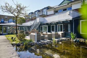 ein Haus mit einem Teich davor in der Unterkunft Dorint Strandresort & Spa Ostseebad Wustrow in Wustrow