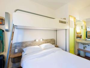 a bedroom with a large white bed and a bunk bed at ibis budget Campinas Aquidaban in Campinas +38 photos