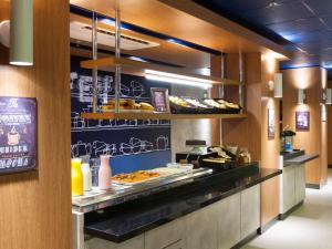 a buffet line with various types of food on display at ibis budget Campinas Aquidaban in Campinas