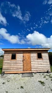 a wooden building with two windows in a field at Cosy Little Hut in Launceston