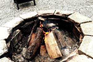 a fire pit with wood and flames in it at #4 Kentucky Bourbon Trail Bourbon Barrel Cottages in Lawrenceburg