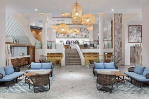 a lobby with chairs and tables and a staircase at DoubleTree by Hilton Bodrum Isil Club All-Inclusive Resort in Torba