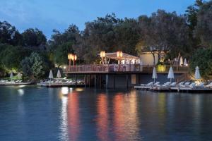 a house on a dock on a body of water at DoubleTree by Hilton Bodrum Isil Club Ultra All-Inclusive Resort in Torba