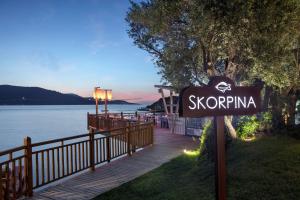 a sign on a boardwalk next to a body of water at DoubleTree by Hilton Bodrum Isil Club Ultra All-Inclusive Resort in Torba