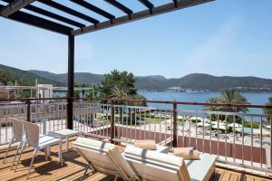 a balcony with chairs and a view of the water at DoubleTree by Hilton Bodrum Isil Club Ultra All-Inclusive Resort in Torba