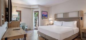 a bedroom with a large white bed and a desk at DoubleTree by Hilton Bodrum Isil Club Ultra All-Inclusive Resort in Torba