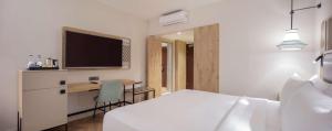 a bedroom with a bed and a desk and a tv at DoubleTree by Hilton Bodrum Isil Club Ultra All-Inclusive Resort in Torba