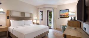 a bedroom with a large white bed and a desk at DoubleTree by Hilton Bodrum Isil Club Ultra All-Inclusive Resort in Torba