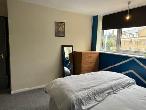 a bedroom with a bed and a mirror and a window at Lux Apartment in Southwark in London