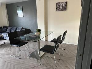 a dining room with a glass table and black chairs at Lux Apartment in Southwark in London