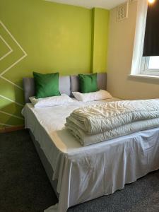 a bedroom with a large bed with green walls at Lux Apartment in Southwark in London